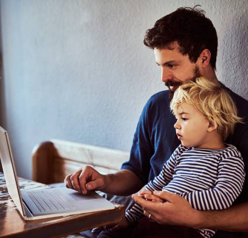father and son in front of a laptop